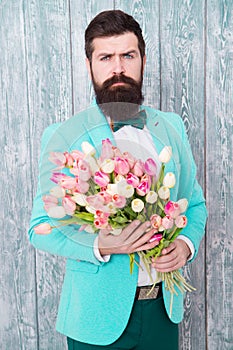 To say I love you. Womens day. Flower for March 8. Spring gift. Bearded man hipster with flowers. Bearded man with tulip