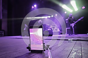 To shoot a rock band concert on the phone using a monopod