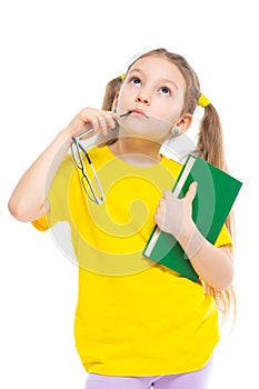 To think. Cheerful young child girl with glasses holding a book to study isolated on a white background.
