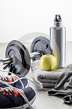 To work out with dumbbells, aluminium bottle and healthy apple