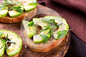 Toast with avocado, herbs on wooden board