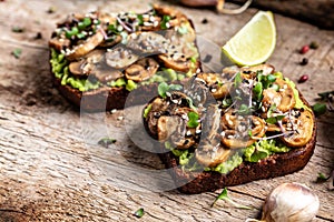 Toast avocado, mushrooms and microgreen whole grain sandwich. Decorated with sesame. Vegetarian food. Vegan menu. Food recipe