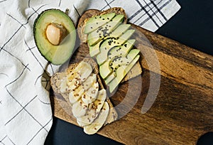 Toast with avocado, sesame and peanut butter on whole grain bread and toast with banana and flaxseed on whole wheat bread