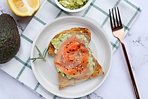 Toast with avocado and smoked salmon sprinkled on top with sesame seed
