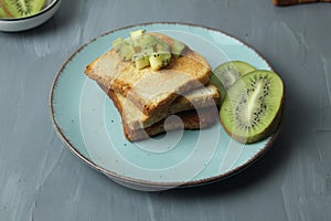 Toast bread on a plate with slices of kiwi fruit on a plate. Healthy breakfast