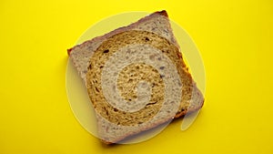 Toast bread rotating on a yellow background. Toast bread from rye flour with cereals, minimal food concept