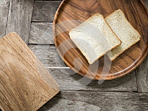 Toast bread on wooden plate and wooden breadboard