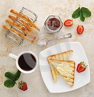 Toast with butter and jam on plate and cup of tea