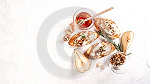 Toast with cheese, pear, honey and nuts. Delicious breakfast or snack with brie camembert cheese on a light background, top view