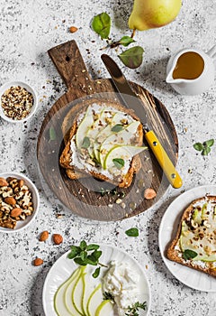 Toast with cheese, pear, honey and nuts. Delicious breakfast or snack on a light background