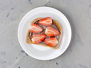 Toast with chocolate and strawberry, Single sandwich with chocolate cheese on white plate, top view