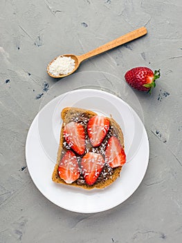 Toast with chocolate and strawberry, Single sandwich with chocolate cheese on white plate, top view