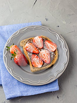 Toast with chocolate and strawberry, Single sandwich with chocolate cheese on white plate, top view