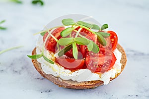 Toast with cream cheese, cherry tomatoes and micro greens. Healthy breakfast concept