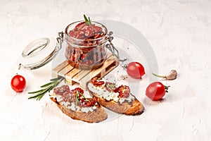 Toast with goat cheese, sun-dried tomatoes and garlic, oregano, olive oil on a light table, top view. place for text. concept of