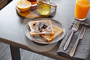 Toast With Honey and Berries. Honey Jar With Dipper and Orange Are on Background. Concept of Healthy Breakfast.