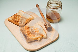 Toast with honey sliced on a wooden board