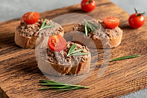 Toast with liver pate on a wooden board. Open sandwich with liver pate. Side view, selective focus