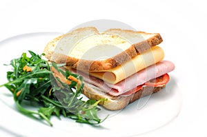 Toast sandwich with ham, cheese, tomatoes and salad on white plate, on white background