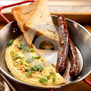 Toast, sausages and omelet in skillet or frying pan. Simple breakfast. Good morning concept. Close-up shot. Soft focus