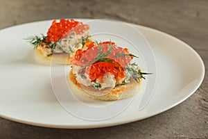 Toast skagen - classic Swedish appetizer. Sandwiches with shrimps and caviar on white plate. Selective focus