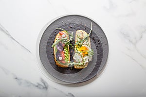 Toast with veggies,avocado, aragula, basil, tomato, mozzarella cheese and sunny side up egg