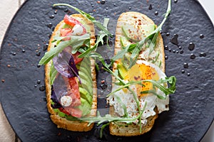 Toast with veggies,avocado, aragula, basil, tomato, mozzarella cheese and sunny side up egg