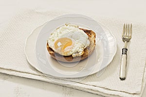 Toasted Bagel with Fried Egg on White Plate