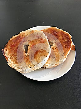 Toasted bagel halves on a white plate