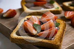 Toasted bread with chocolate candy    food   calories creamy   choco  gourmet  lunch spread strawberries on a wooden background