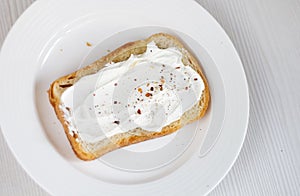 toasted bread with cream cheese, on a white plate background