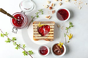 Toasted bread with sweet jam and chocolate paste on table