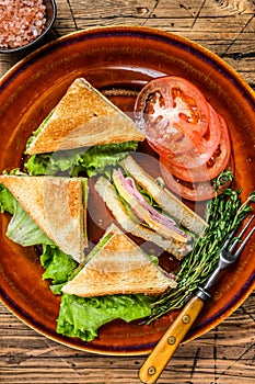 Toasted Club sandwiches with pork ham, cheese, tomatoes and lettuce on a plate. wooden background. Top view