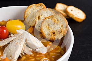 Toasted Crackers, Chicken, Tomatoes with Soup in a White Bowl