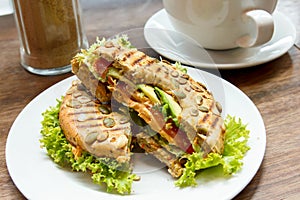 Toasted filled bagel with salad on a white plate.