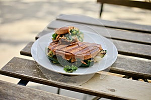 Toasted grilled vegetarian sandwich on a terrace table