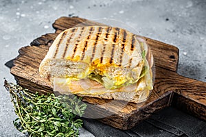 Toasted Panini sandwich with Prosciutto ham and cheese. Gray background. top view