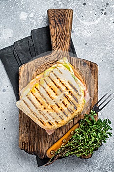 Toasted Panini sandwich with Prosciutto ham and cheese. Gray background. top view