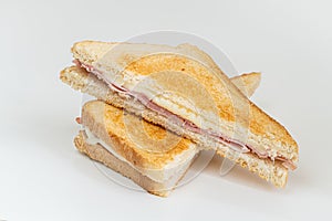 Toasted sandwich with ham and melted cheese, cut in two halves, isolated on white background