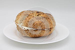 Toasted Sesame Seed Bagel with Cream Cheese on a White Plate