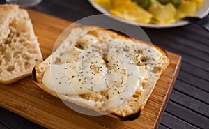 Toasted slices of square bread with warm cheese and and provencal herbs on plate breakfast