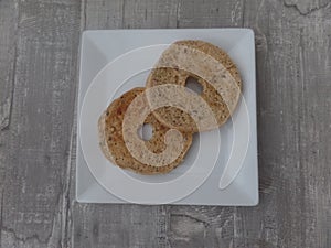 Toasted wholemeal bagel on a white plate