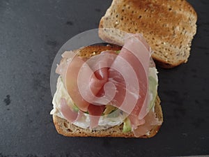 Toasted wholemeal sandwich with avocado, cheese and cured ham