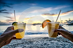 Toasting with tropical drinks on the beach. photo