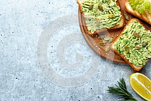 Toasts with avocado paste with sesame seeds on a gray background