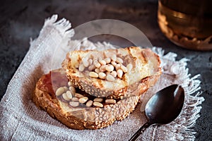 Toasts of bread with sesame seeds homemade cake in stack decorated with pine nut on linen cotton napkin