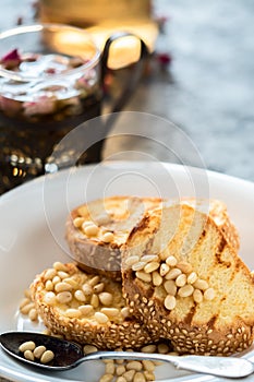 Toasts of bread with sesame seeds homemade cake in stack decorated with pine nut on white plate