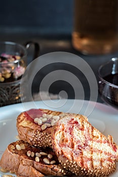 Toasts of bread with sesame seeds homemade cake in stack decorated with pine nut on white plate