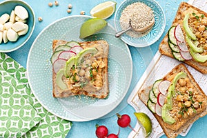 Toasts with chickpea hummus, avocado, fresh radish, cucumber, sesame seeds and flaxseed sprouts. Diet breakfast. Delicious and hea