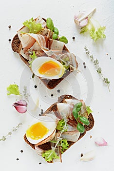 Toasts of rye bread with bacon and egg. Breakfast. photo